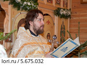 Отец Дмитрий зачитывает рождественское послание. Храм святого великомученика Феодора Тирона. Москва (2014 год). Редакционное фото, фотограф Сергей Соболев / Фотобанк Лори