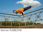 Брейк-данс. Мужчина выполняет трюк, держась за перила. Стоковое фото, фотограф Losevsky Pavel / Фотобанк Лори