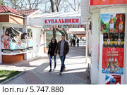 Молодые люди идут мимо ларька "купальники". Республика Крым. г. Феодосия (2014 год). Редакционное фото, фотограф Виктор Филиппович Погонцев / Фотобанк Лори