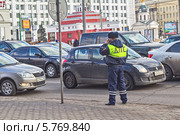 Инспектор ДПС на улице Новый Арбат в Москве на фоне движущегося потока автомашин (2014 год). Редакционное фото, фотограф Владимир Сергеев / Фотобанк Лори