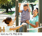 Родители учат сына-подростка подтягиваться на турнике на свежем воздухе. Стоковое фото, фотограф Яков Филимонов / Фотобанк Лори