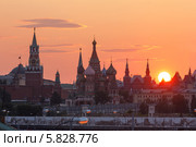 Москва. Башни Кремля, купола собора Василия Блаженного и башни Исторического музея на фоне большого заходящего солнца (2013 год). Редакционное фото, фотограф Горшков Игорь / Фотобанк Лори