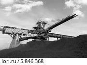 Крутонаклонный консольный штабелер на гусеничном ходу для перевалки угля на фоне неба. Красный фильтр. Черно-белый кадр (2014 год). Редакционное фото, фотограф Валерий Акулич / Фотобанк Лори