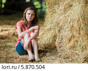 Молодая девушка сидит рядом со стогом сена. Стоковое фото, фотограф Игорь Низов / Фотобанк Лори