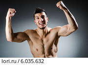 Мужчина с накачанной мускулатурой радуется на сером фоне. Стоковое фото, фотограф Elnur / Фотобанк Лори