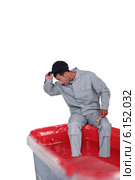 Surprised man sitting on a paint can. Стоковое фото, фотограф Phovoir Images / Фотобанк Лори