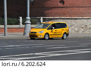 Желтый автомобиль такси двигается по Кремлевской набережной в Москве (2014 год). Редакционное фото, фотограф lana1501 / Фотобанк Лори