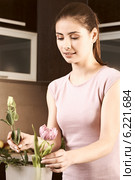 Young woman arranging flowers in the vase. Стоковое фото, агентство BE&W Photo / Фотобанк Лори