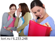 women whispering behind a confused colleague. Стоковое фото, фотограф Phovoir Images / Фотобанк Лори