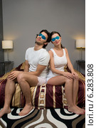 Woman and man sitting on bed with eye compresses. Стоковое фото, агентство BE&W Photo / Фотобанк Лори