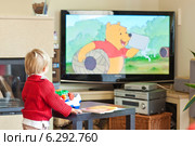 A child watching tv at home. Редакционное фото, агентство BE&W Photo / Фотобанк Лори