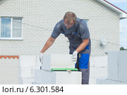 Рабочий укладывает газосиликатные блоки. Стоковое фото, фотограф Андрей Батурин / Фотобанк Лори