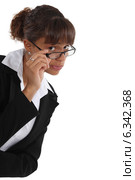 Critical woman peering over her glasses. Стоковое фото, фотограф Phovoir Images / Фотобанк Лори