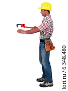 Tradesman using a pipe wrench. Стоковое фото, фотограф Phovoir Images / Фотобанк Лори