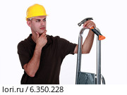 Doubtful man holding a hammer. Стоковое фото, фотограф Phovoir Images / Фотобанк Лори