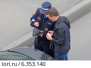 Сотрудник ГИБДД демонстрирует нарушителю показания радара (2014 год). Редакционное фото, фотограф Александр Тарасенков / Фотобанк Лори