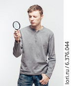 Man looking through a magnifying glass. Стоковое фото, агентство Ingram Publishing / Фотобанк Лори