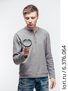 Man looking through a magnifying glass. Стоковое фото, агентство Ingram Publishing / Фотобанк Лори