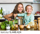 Woman with baby cooking at kitchen. Стоковое фото, фотограф Яков Филимонов / Фотобанк Лори