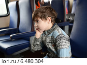 Задумчивый мальчик в поезде. Стоковое фото, фотограф Ирина Ращектаева / Фотобанк Лори