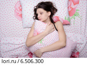 Молодая девушка испуганно обнимает подушку, лежа в постели. Стоковое фото, фотограф Иванов Алексей / Фотобанк Лори