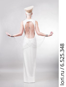 blond woman in white dress with creative hairstyle from back. Стоковое фото, фотограф Александр Буц / Фотобанк Лори