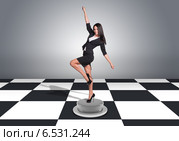 Красивая бизнес-леди стоит на шахматном поле в торжествующей позе. Стоковое фото, фотограф Кирилл Черезов / Фотобанк Лори