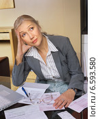 A pensive woman sitting near some documents. Стоковое фото, агентство BE&W Photo / Фотобанк Лори