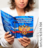 Женщина держит в руках и читает книгу "Конституция Российской Федерации" Стоковое фото, фотограф Яна Королёва / Фотобанк Лори