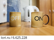 Две чашки с надписями ON и OFF стоят на кухонном столе. Стоковое фото, фотограф Кекяляйнен Андрей / Фотобанк Лори