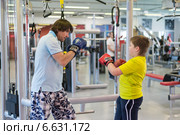Отец с сыном боксируют в спортзале (2014 год). Редакционное фото, фотограф Володина Ольга / Фотобанк Лори
