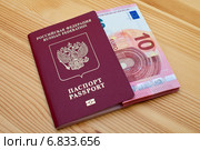 Заграничный паспорт гражданина Российской Федерации с вложенной пачкой купюр номиналом 10 евро. Стоковое фото, фотограф Александр Тарасенков / Фотобанк Лори