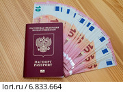 Заграничный паспорт гражданина Российской Федерации с вложенной пачкой купюр номиналом 10 евро. Стоковое фото, фотограф Александр Тарасенков / Фотобанк Лори