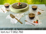 Пасхальный стол с чизкейком, чашками чая и черным кофе на фоне зеленой травы. Стоковое фото, фотограф Зинаида Зайко / Фотобанк Лори