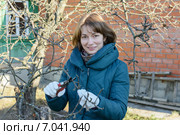 Девушка обрезает  ветви яблони осенью. Стоковое фото, фотограф Марина Славина / Фотобанк Лори