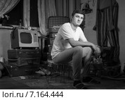 Мужчина с чайником в руках сидит в грязной неубранной квартире. Стоковое фото, фотограф Вячеслав Николаенко / Фотобанк Лори