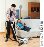 Man cleaning while woman lying with laptop. Стоковое фото, фотограф Яков Филимонов / Фотобанк Лори