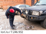 Мужчина протирает номер автомобиля от грязи (2014 год). Редакционное фото, фотограф Сергей Лаврентьев / Фотобанк Лори