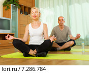 Elderly couple having yoga at home. Стоковое фото, фотограф Яков Филимонов / Фотобанк Лори