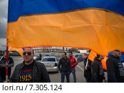 Армянский мужчина держит национальный флаг Армении перед началом митинга в день памяти жертв геноцида армян в 1915 году на территории Османской империи в парке имени Горького в Москве, Россия (2015 год). Редакционное фото, фотограф Николай Винокуров / Фотобанк Лори