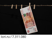 Купюра номиналом 5000 рублей висит на миниатюрной прищепке. Стоковое фото, фотограф Константин Пекарь / Фотобанк Лори