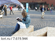 Московский фестиваль "Книги России" 2015 на Красной площади, молодой человек зачитался книгой. Редакционное фото, фотограф Дмитрий Неумоин / Фотобанк Лори