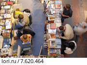 Московские букинисты подбирают себе старую  книгу в ГУМе (2015 год). Редакционное фото, фотограф Дмитрий Неумоин / Фотобанк Лори