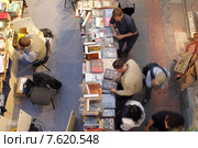 Московские букинисты подбирают себе старую  книгу в ГУМе (2015 год). Редакционное фото, фотограф Дмитрий Неумоин / Фотобанк Лори