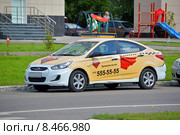 Немного поцарапанный автомобиль Hyundai Solaris ("Хендай Солярис") в частичной расцветке службы Red Taxi ("Ред Такси"), припаркованный у края дороги (2015 год). Редакционное фото, фотограф Александр Замараев / Фотобанк Лори