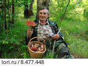 Довольный грибник с корзиной грибов нашел большой подосиновик. Стоковое фото, фотограф Яна Королёва / Фотобанк Лори