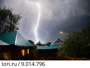 Сильный и мощный удар молнии над домами в деревне ночью. Стоковое фото, фотограф Михаил Дударев / Фотобанк Лори