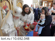 Митрополит Ювеналий в Петропавловском храме города Лыткарино причащает детей (2015 год). Редакционное фото, фотограф Дмитрий Неумоин / Фотобанк Лори