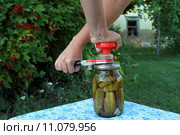 Руки женщины закатывающие банку с огурцами. Закаточный ключ. Стоковое фото, фотограф Александров Никита / Фотобанк Лори