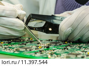 Woman in antistatic gloves holding pincette and magnifier. Стоковое фото, фотограф Sergey Kuznetsov / PantherMedia / Фотобанк Лори